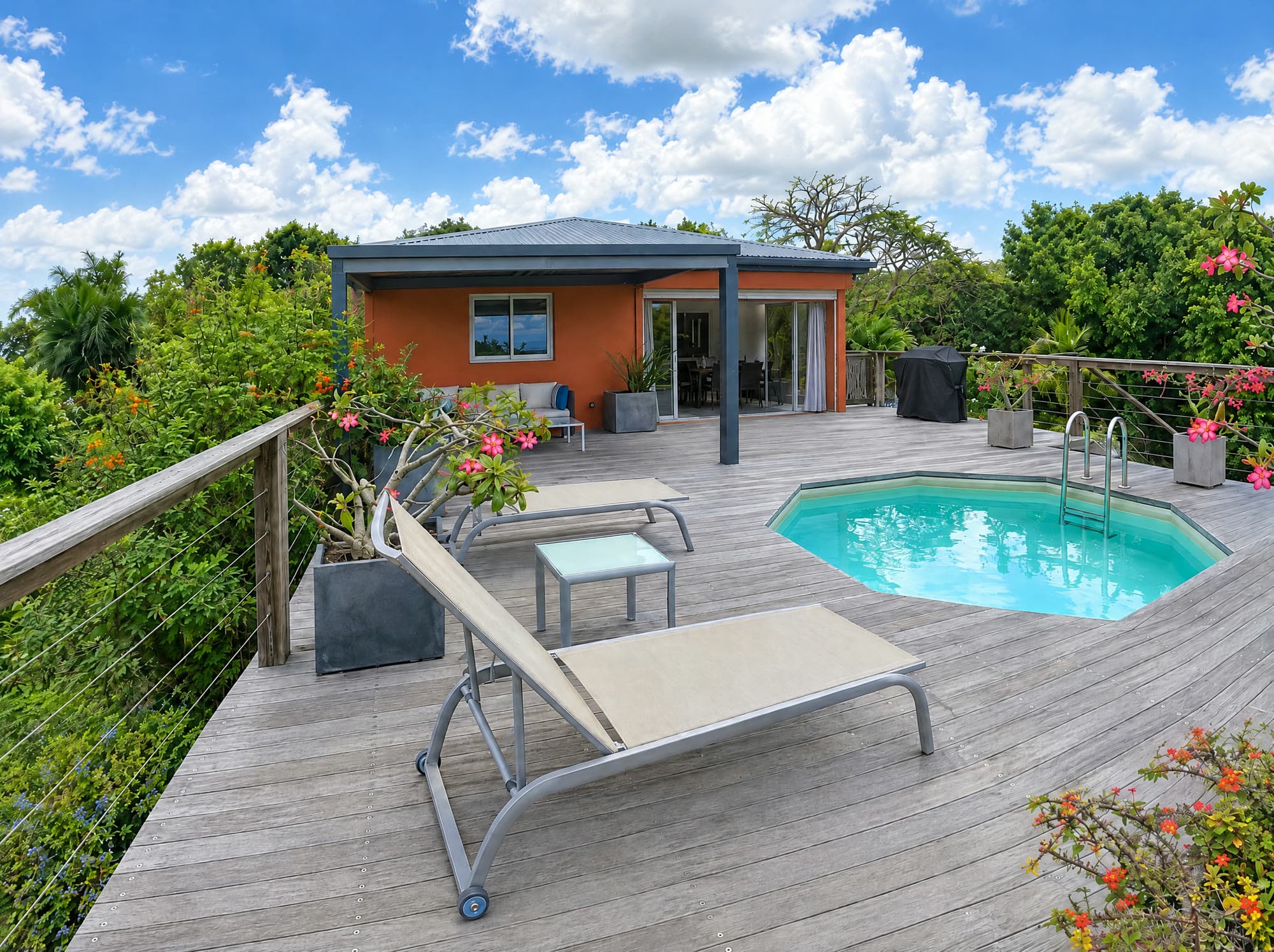 The coral-toned villa with its sliding doors open beside the plunge pool and sun loungers